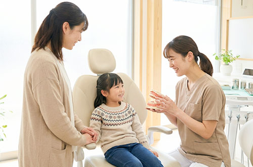 子供に優しく説明する歯科医師