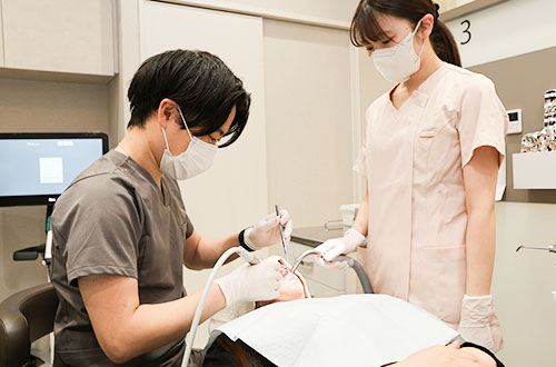 歯の状態を検査する歯科医師と歯科スタッフ