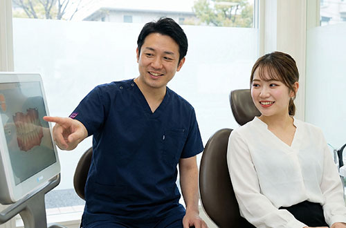 患者さんに治療内容を説明する歯科医師