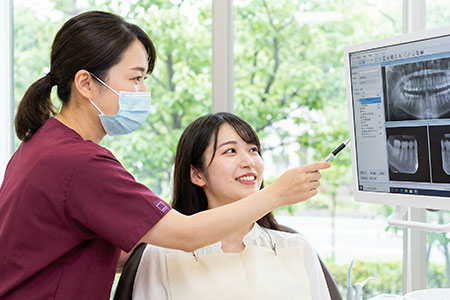 レントゲンを見て説明する歯科医師