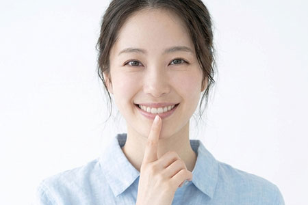 口元を指さす女性