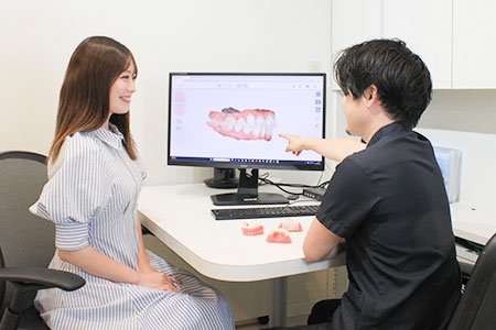 3Dシミュレーションで歯の動きを説明する歯科医師