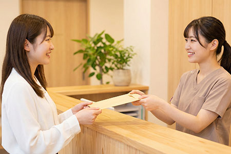 受付スタッフと話す女性