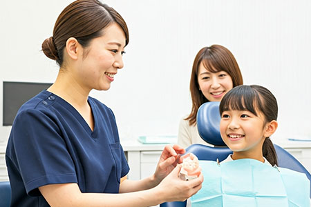 歯科医師に歯並びの説明を受ける親子
