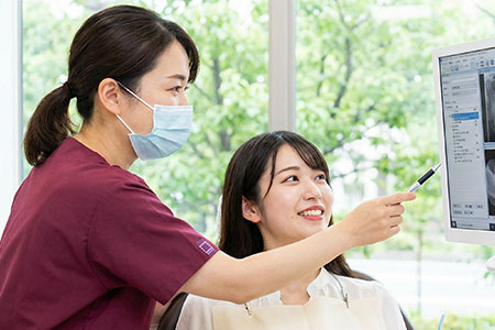 モニターを見て説明する歯科医師