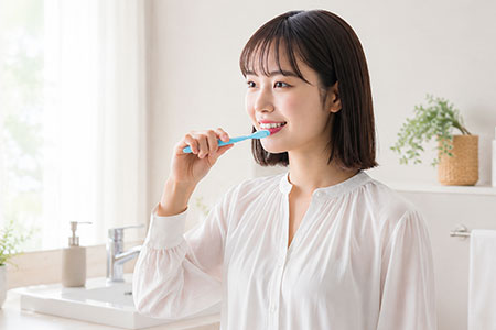 明るい洗面で歯みがきをする女性