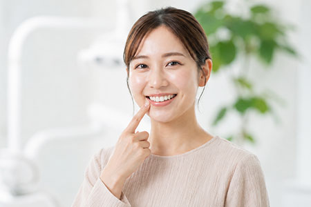 歯科医院で歯を指さす女性