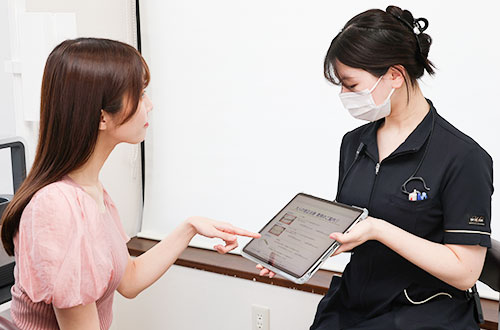 タブレットで説明をする歯科スタッフ