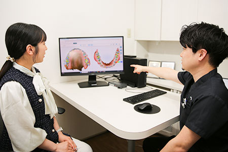 モニターを使って説明する歯科医師