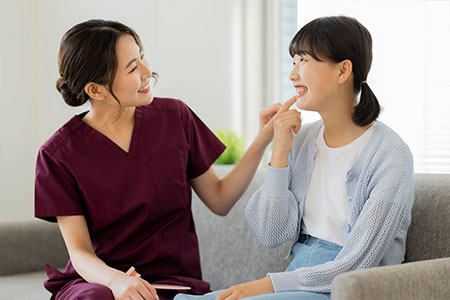 患者さんの歯を確認する歯科衛生士